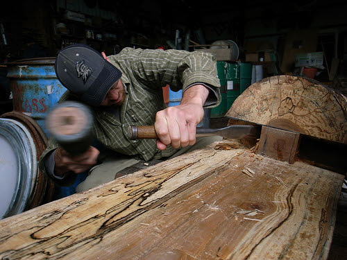timber frame construction - chiseling a log
